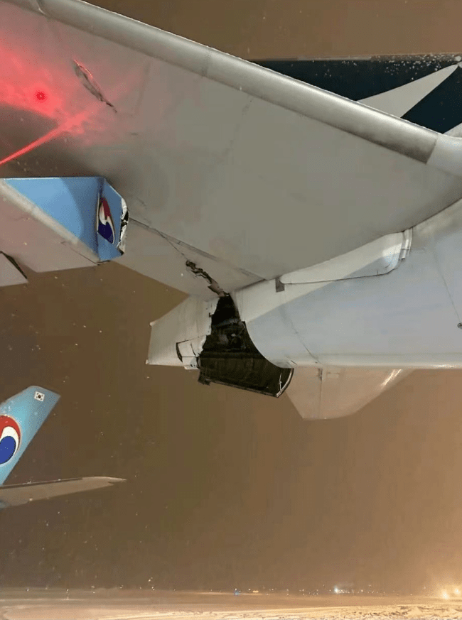 A part of wing of a Korean Air plane, left, and Cathay Pacific aircraft, right, are seen after a collision