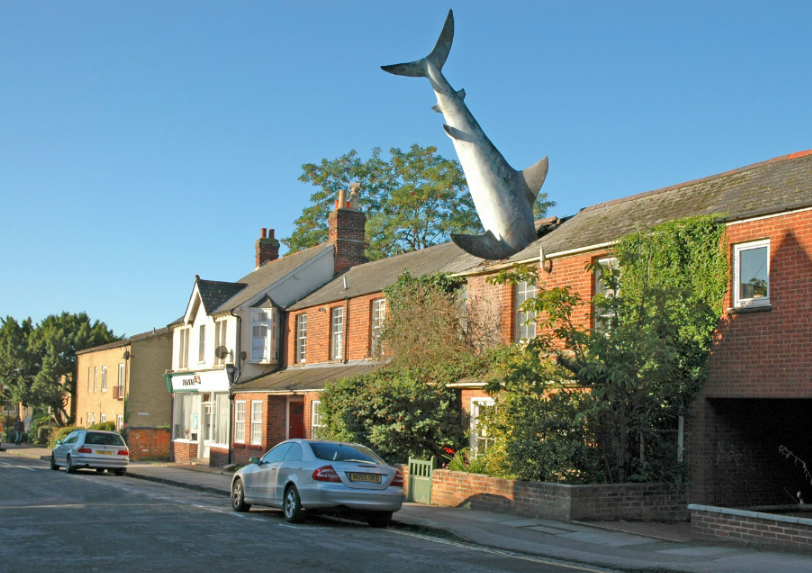 A 'Jaws' inspired house with a 25ft shark crashing through the roof has been banned from Airbnb