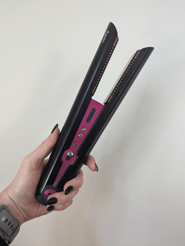 Hand holding a Dyson hair straightener.