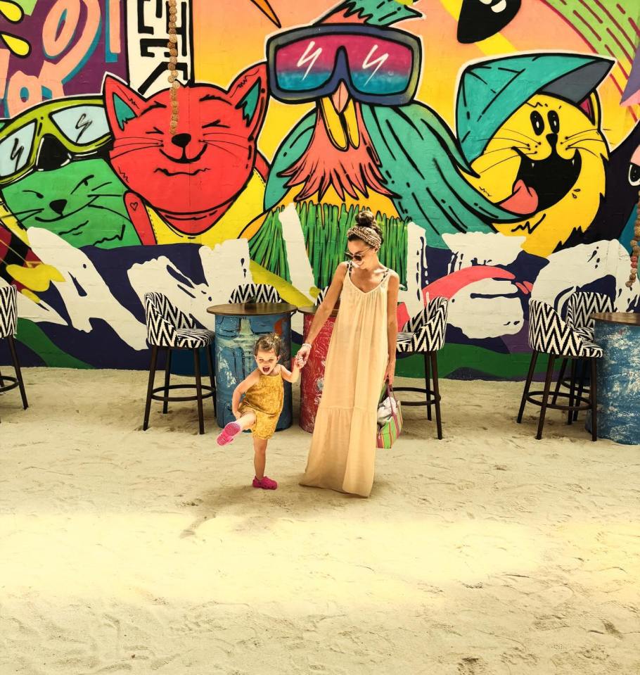 Louisa and her daughter posed against a colourful mural