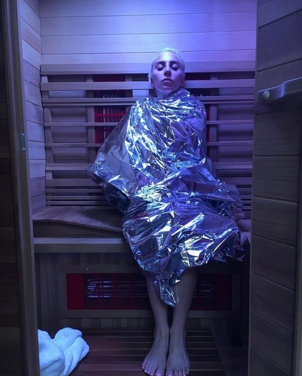 Lady Gaga, wrapped in a foil blanket, using an infrared sauna