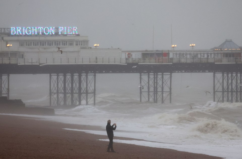 A man records high sea waves in Brighton during Storm Isha