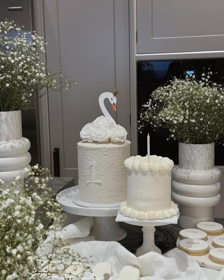 a white cake with a swan on top has the number 1 on it