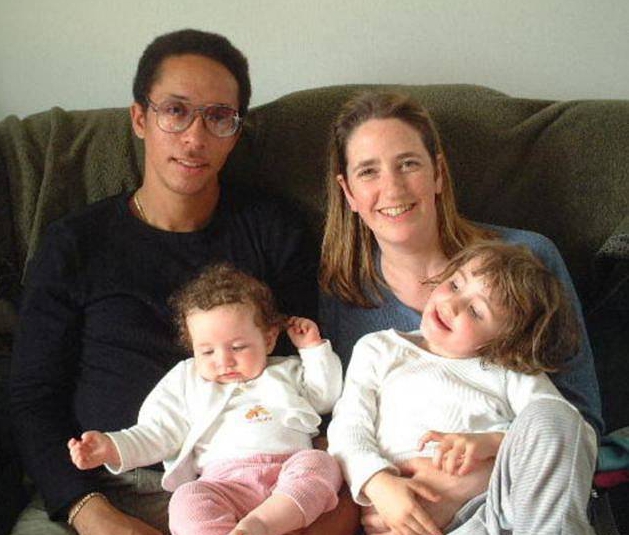 a family is posing for a picture while sitting on a couch .