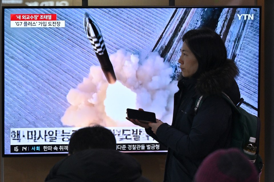 People watch a television screen showing file footage of a North Korean missile test, at a railway station in Seoul