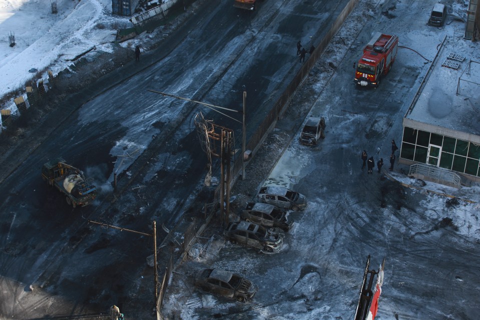 Police officers inspect damage at the scene of the explosion