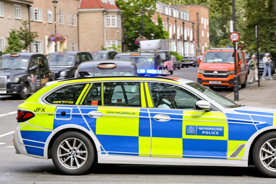 London, England, UK – 24 August 2023: Police patrol car of the Metropolitan Police driving through central London with blue lights flashing