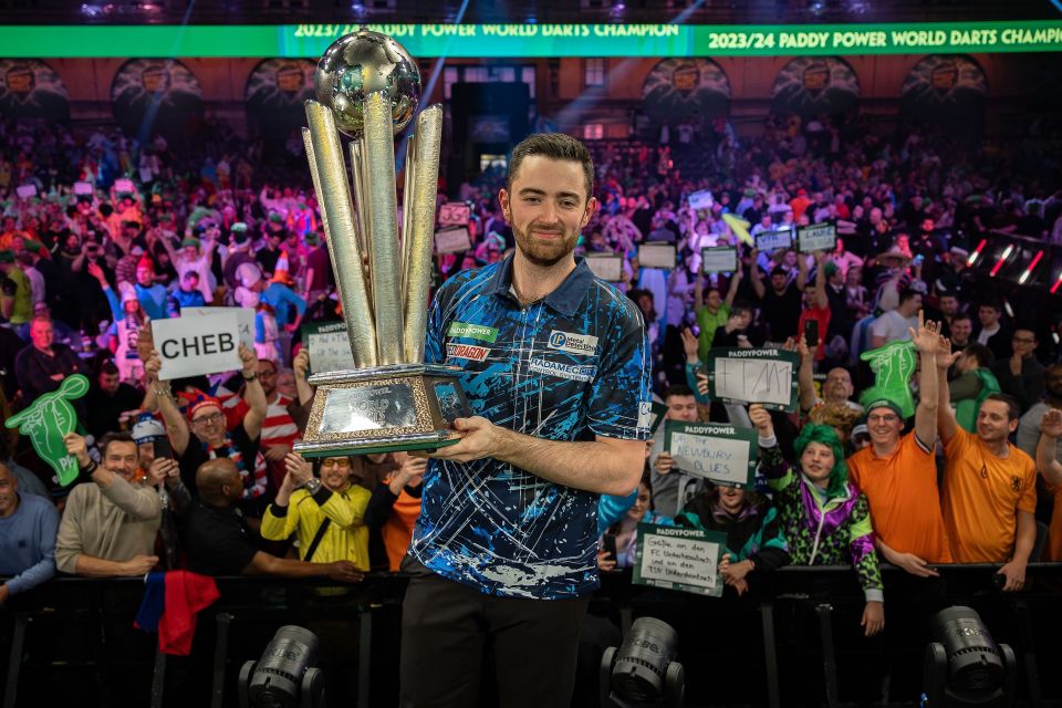 Luke Humphries gleefully clutches his trophy