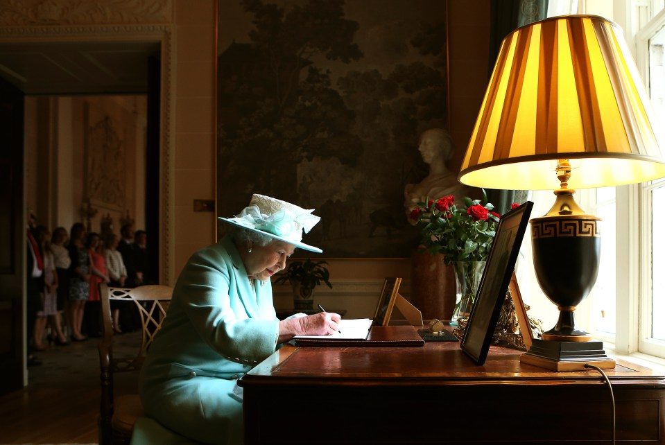 Queen Elizabeth II signs the visitor book prior to departing Hillsborough Castle, on the third and final day of the Queen’s visit to Northern Ireland