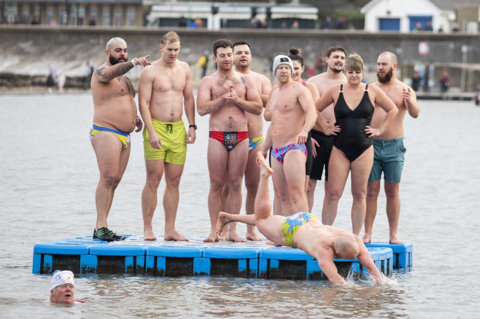 Swimmers take turns diving at Clevedon Marine Lake in Somerset