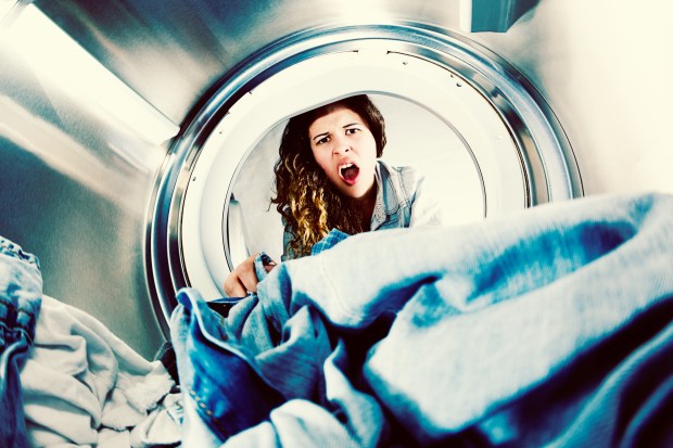 a woman is looking out of a washing machine with her mouth open