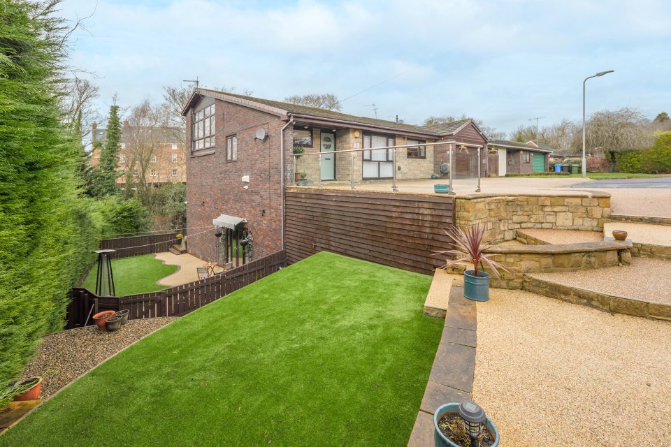 Hidden behind the 'bungalow' front is a landscaped lawn area and decking