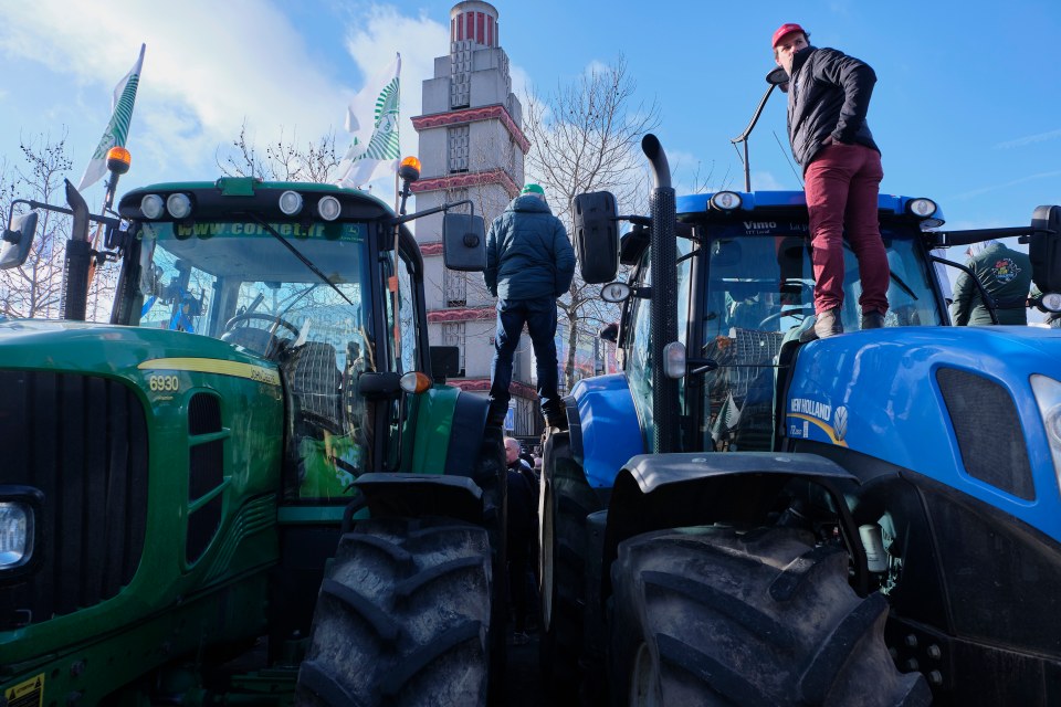 Farmers stand on their tractors outside the agricultural fair as tensions run high in Paris, France