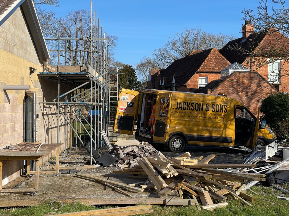 A pile of rubble and wooden beams are strewn across the garden as builders take down the illegal facility