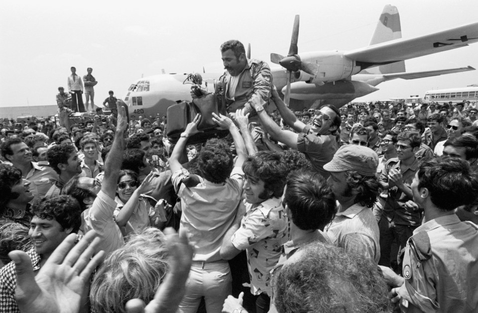 A crowd lifts the squadron leader of the rescue planes on their return to Israel