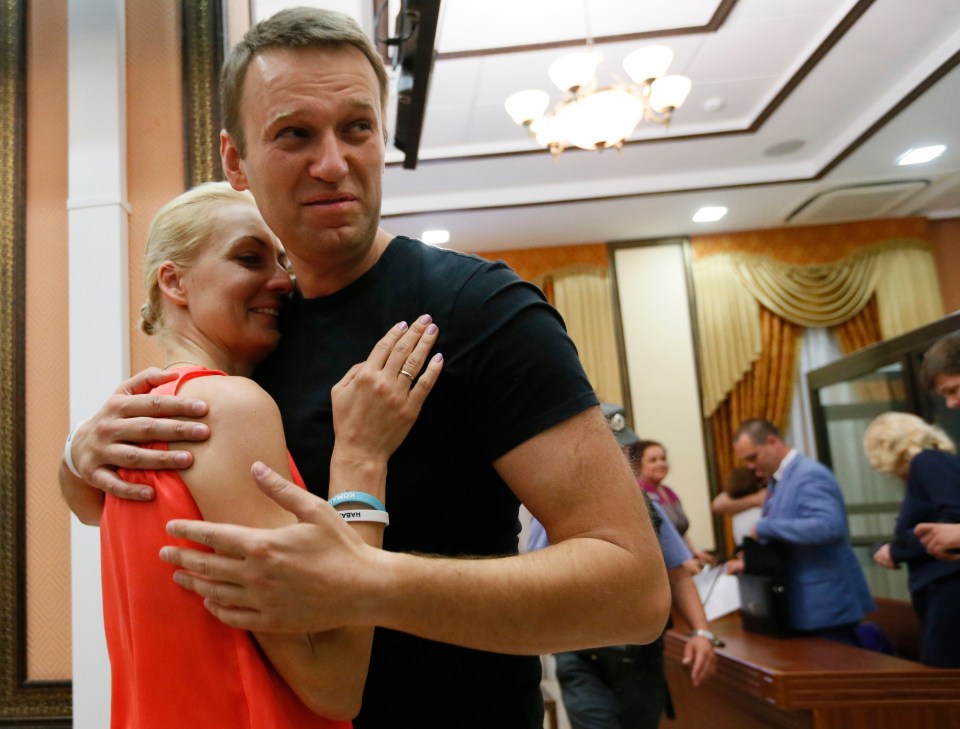 The late Navalny, right, embraces his wife Yulia as he is released in a Russian courtroom on July 19, 2013