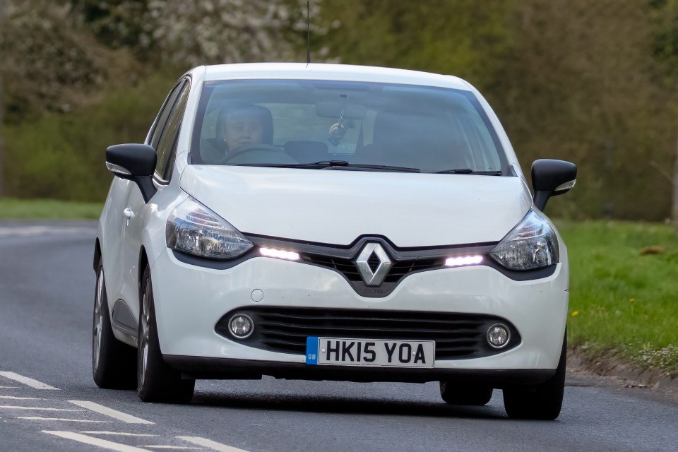 White Renault Clio driving on a road.