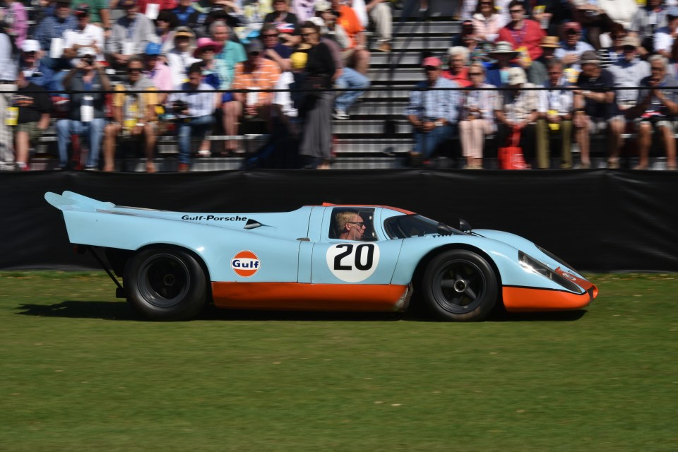 An attendee drives in a 1969 Porsche AG 917k race vehicle, formerly driven by actor Steve McQueen in the movie “Le Mans”