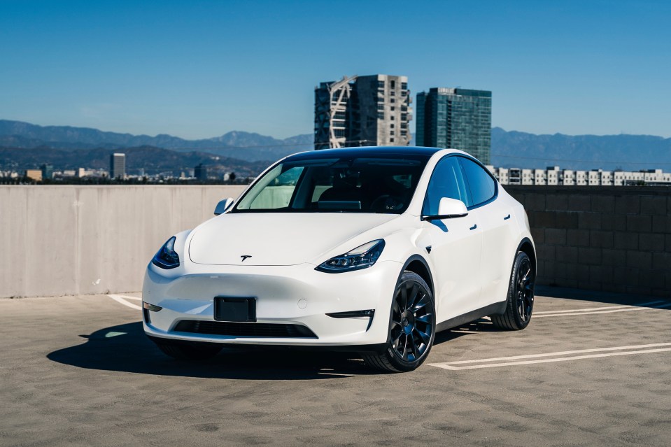 White Tesla Model Y parked in a parking lot.