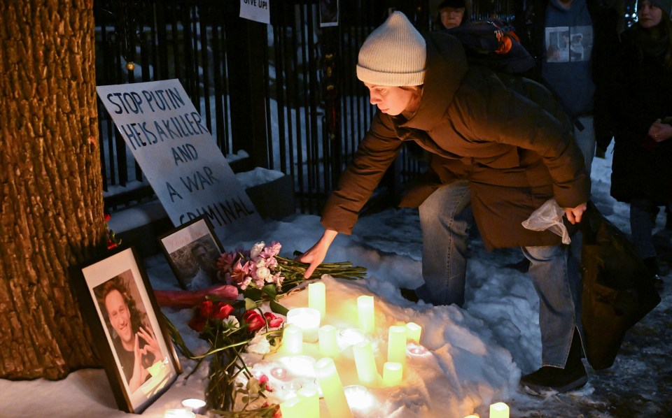 A woman leaves flowers at a memorial for Navalny outside the Russian consulate in Montreal