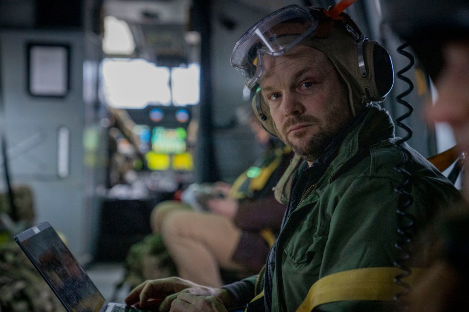 The Sun's man Jerome Starkey flying in a Royal Navy helicopter as he visits Brit troops in their arctic training camp