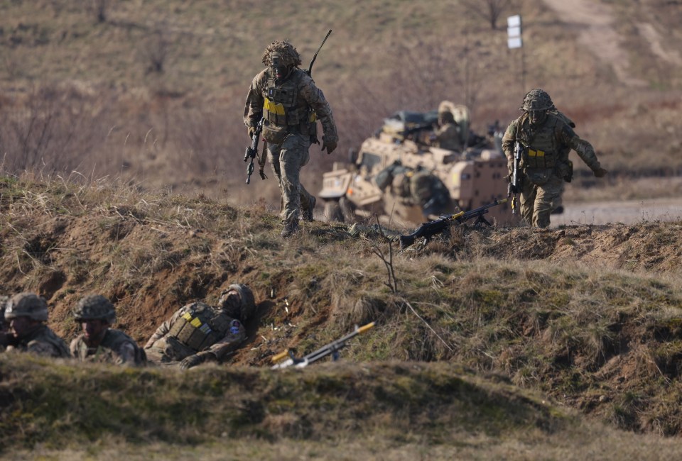 Soldiers of the UK's 2nd Battalion Royal Anglian infantry unit storm an enemy position in a simulated attack