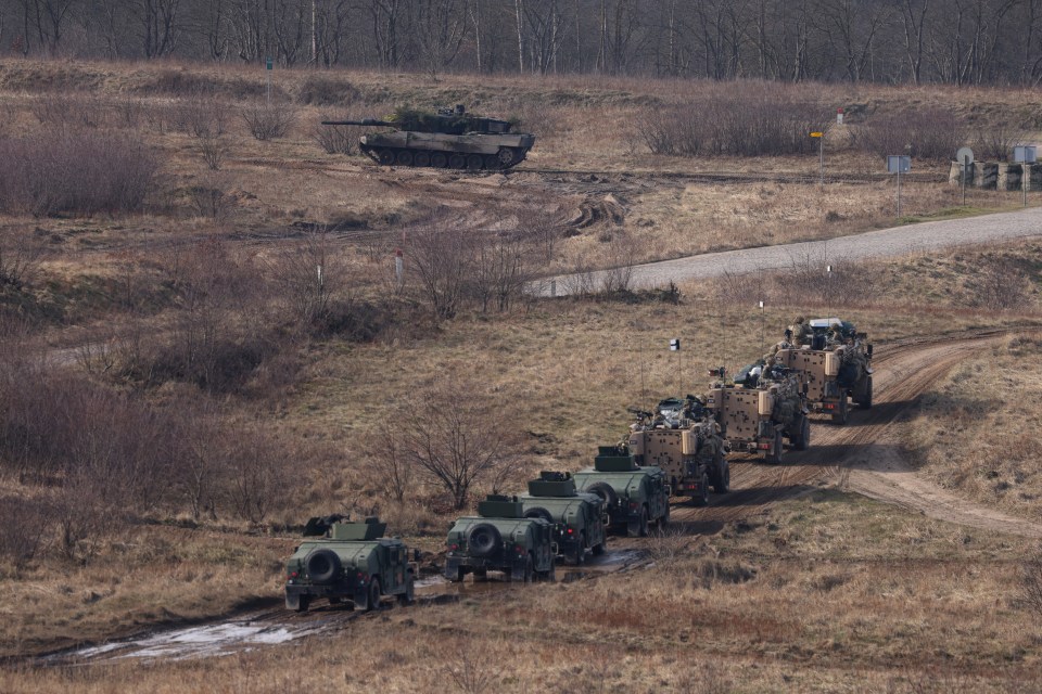 A Leopard 2 main battle tank drives past Albanian and British vehicles during a Nato military exercise on Monday