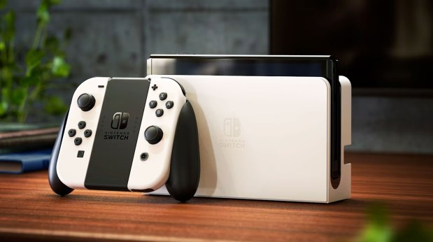 a white nintendo switch sits on a wooden table