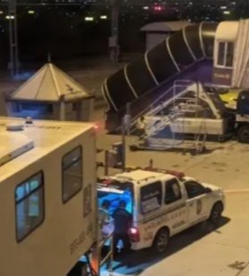 A man being put into an ambulance after he died next to his wife mid-flight after coughing up blood