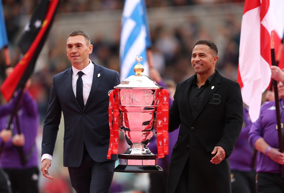 Kevin Sinfield and Robinson carry the Rugby League World Cup 2021 trophy during the opening ceremony at St James' Park