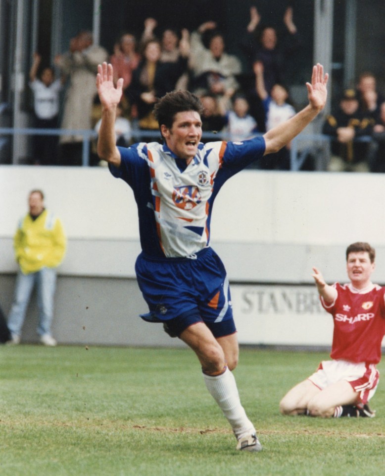 Mick Harford celebrates scoring against Man Utd as Denis Irwin looks on