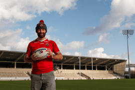 a man in a steeden jersey holds a rugby ball