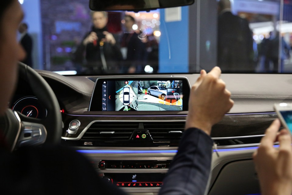 A man uses hand gestures to control the rear parking camera of a BMW