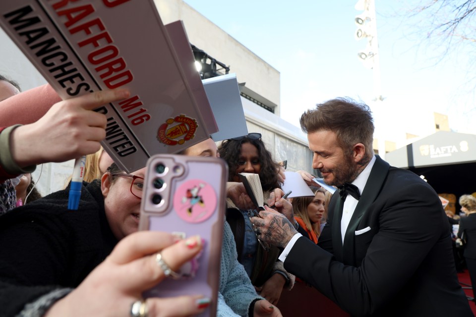 David Beckham signs autographs for fans waiting at the red carpet