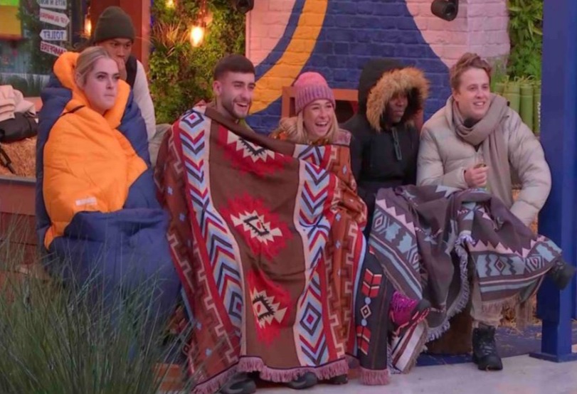 a group of people are wrapped in blankets and sleeping bags