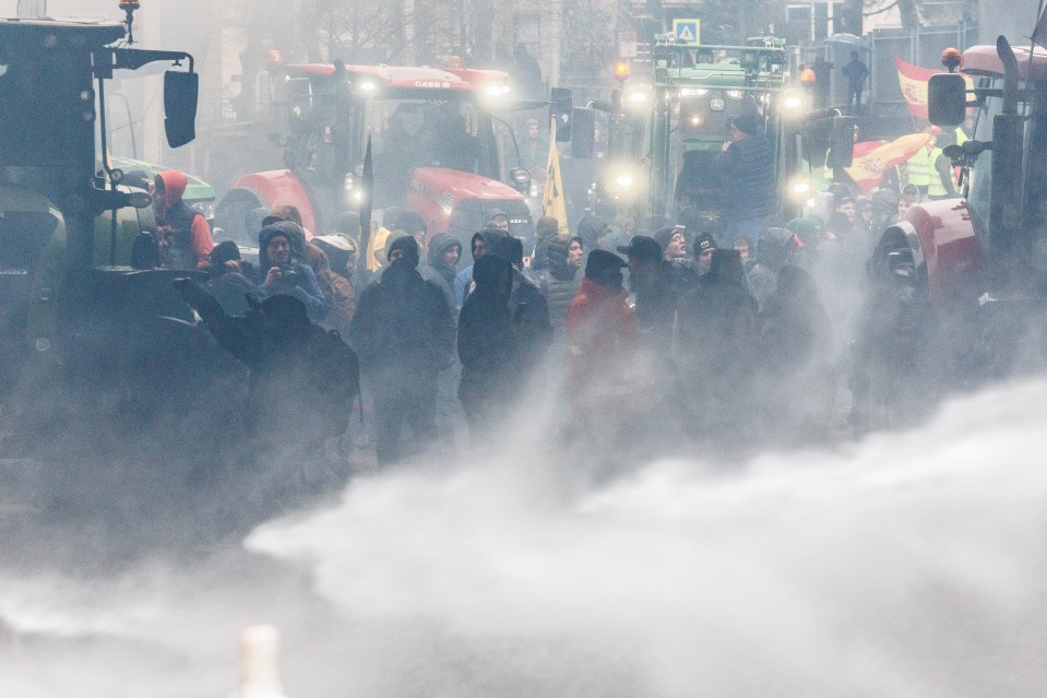 Police forces use water cannon during a protest of European farmers