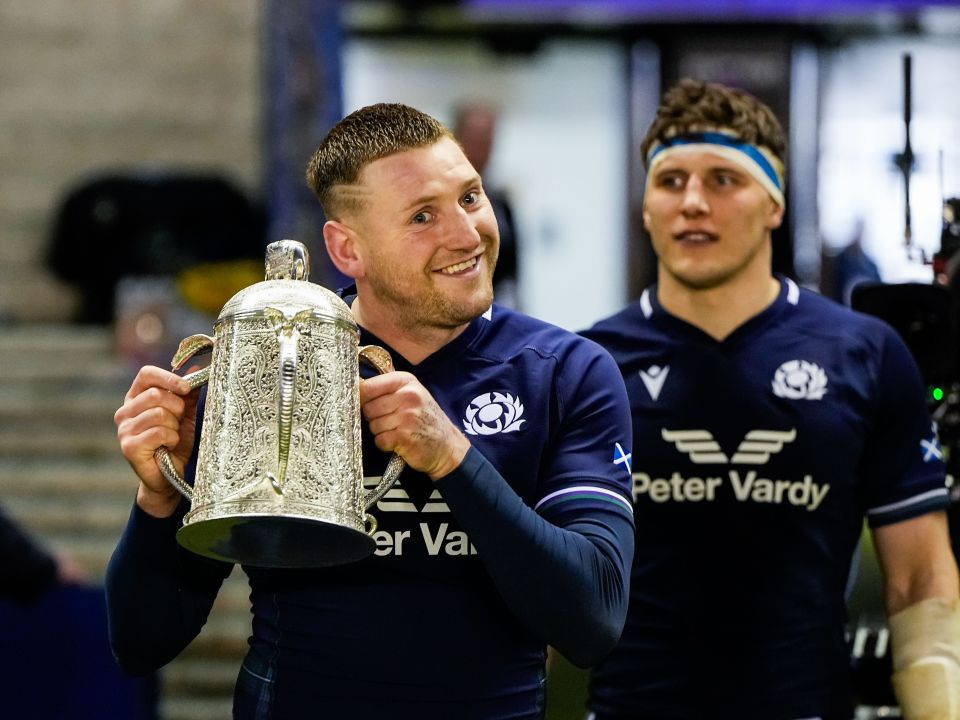 Finn Russell of Scotland holding the Calcutta Cup after a rugby match.