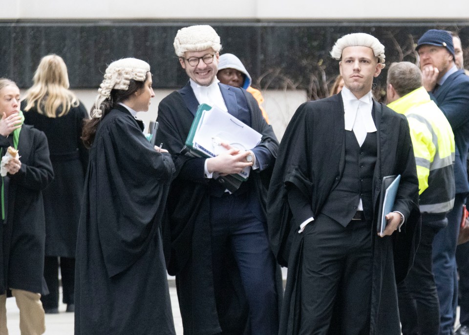 Dozens of barristers in black gowns and wigs lined the street