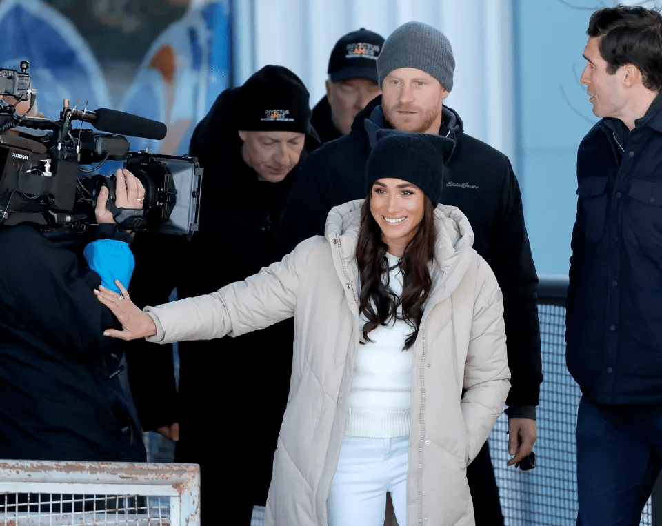 Meghan appeared to budge a camera person aside