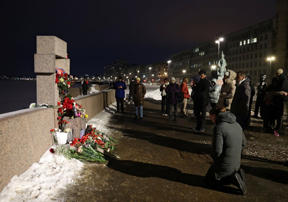 People gather at the monument to the victims of political repressions in Saint Petersburg