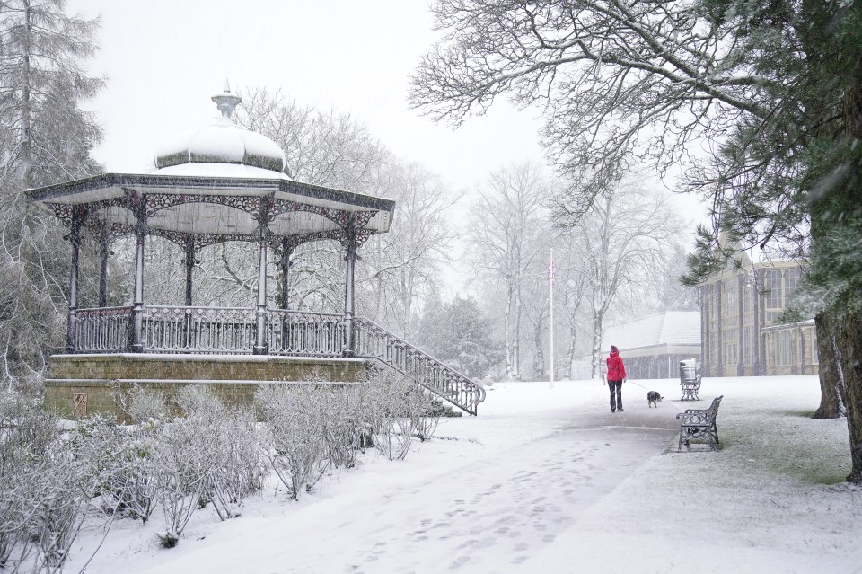 A person walks a dog through Pavilion Gardens, Buxton, Peak District, today