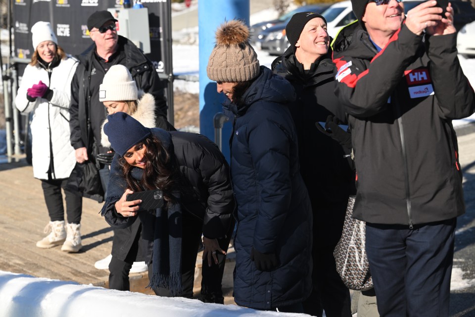 Beaming Meghan Markle snapped pictures of Prince Harry in a skeleton race today