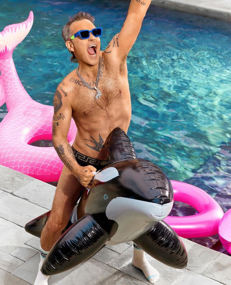 The singer flashed his six pack while messing around with an inflatable whale