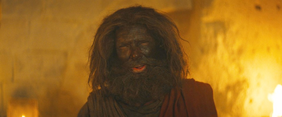 The star is seen in the trailer with matted brown hair and a muddied face