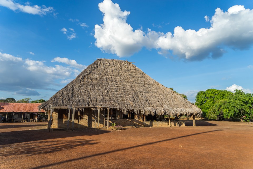 My traditional clay hut, complete with thatched roof, features a vast bed, concrete floors, outdoor bathroom