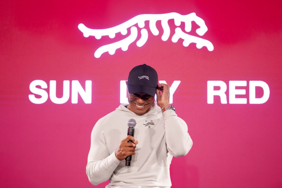 Tiger Woods laughs as he takes questions at the launch