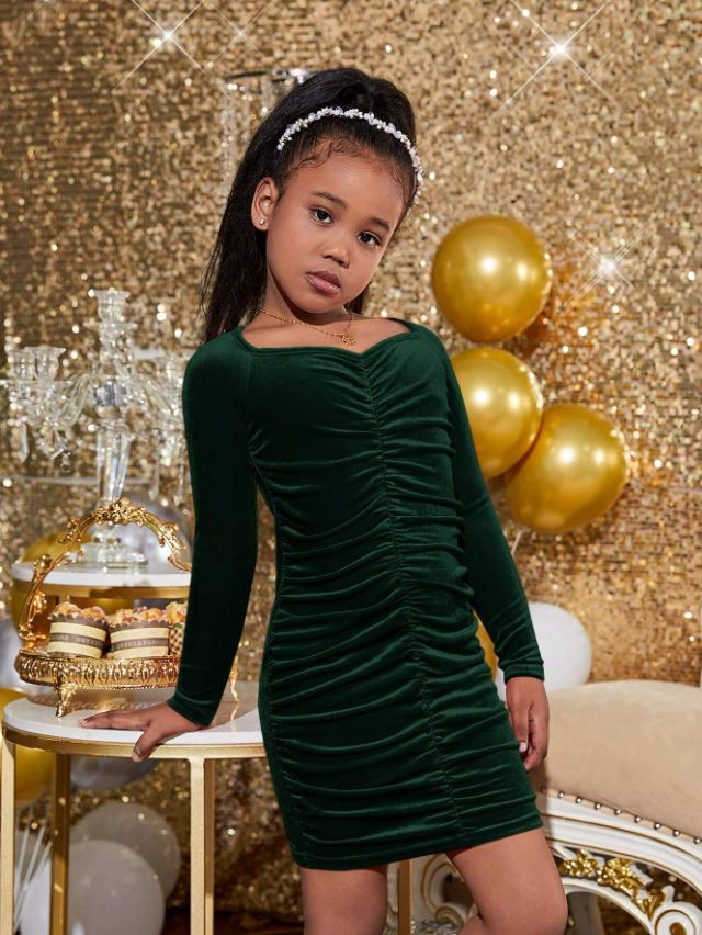 A tasteless photo shows a young Shein model wearing a green bodycon dress with a dipping neckline