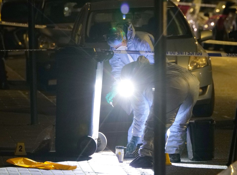 Cops inspect a coffee cup left at the scene