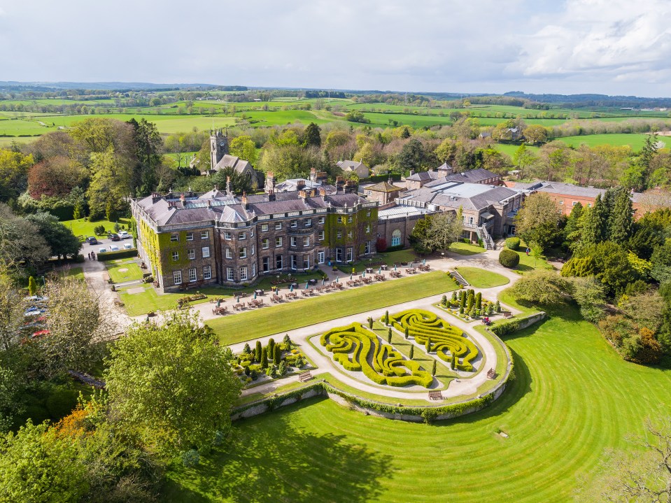 an aerial view of a large building with a maze in front of it