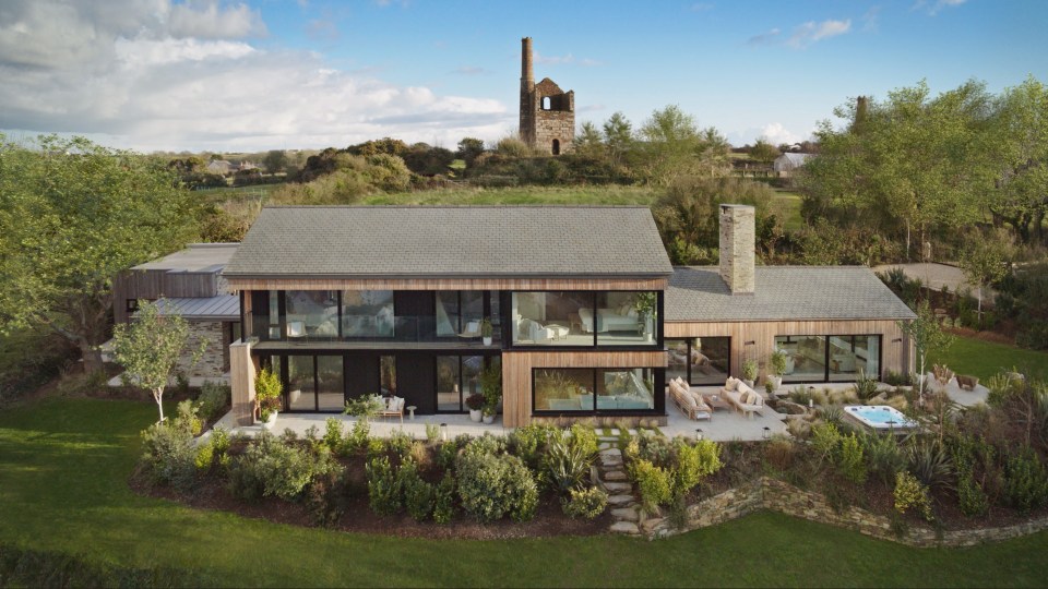 an aerial view of a house with a tower in the background